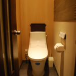 【After】トイレは和式から洋式に。床は清潔感があり手入れしやすいように。また壁面にはエコカラットという機能性タイルを採用しました。消臭・調湿効果があり、また壁面のアクセントになっています。